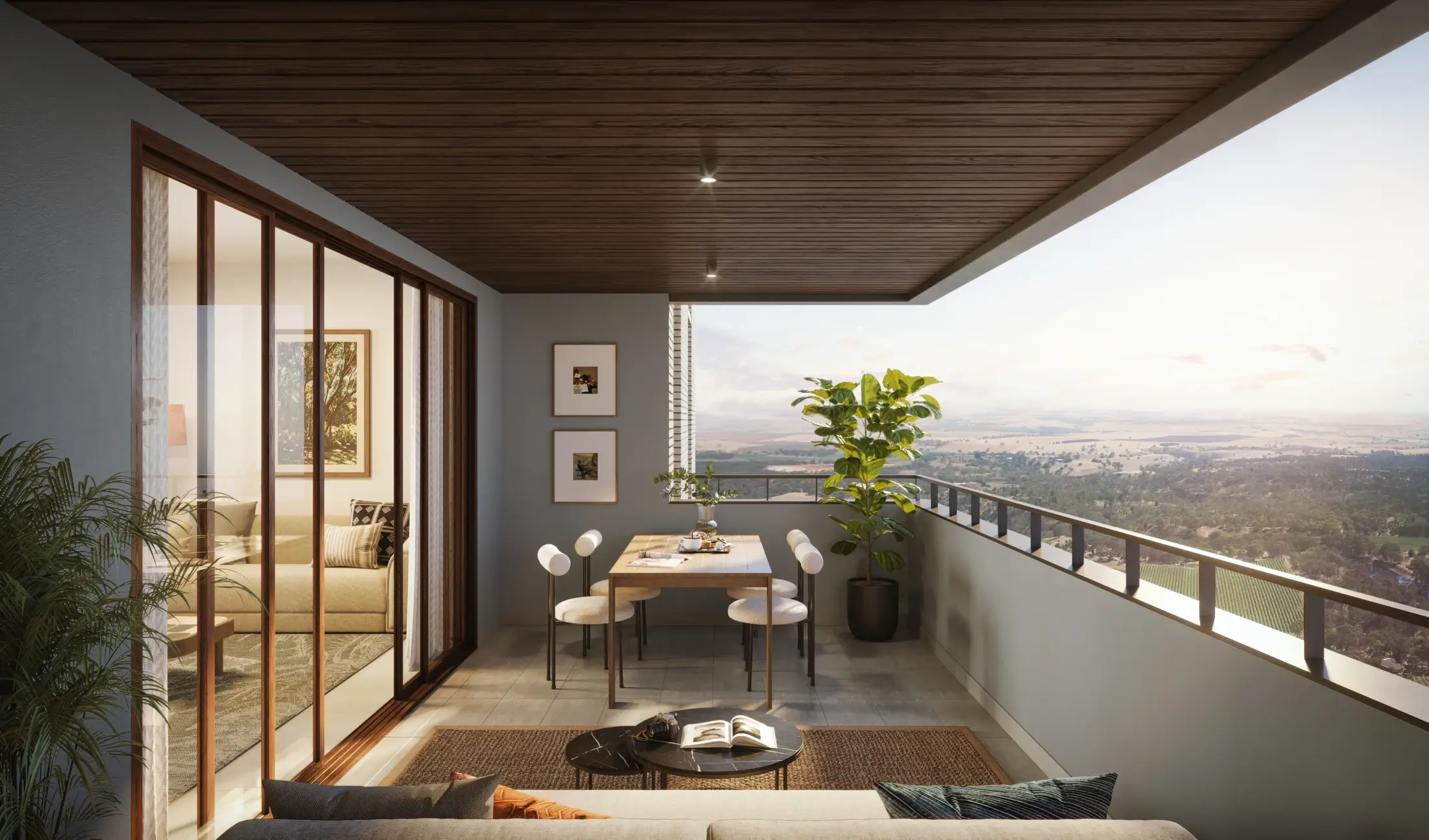 A deep terrace balcony with a timber ceiling, a small dining set and a view over green North Bengaluru.